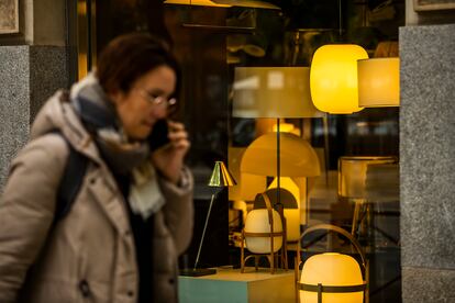 Una viandante pasa frente a una tienda de lámparas de Madrid.