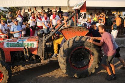 Varias personas ayudan a empujar un tractor averiado durante la prueba.