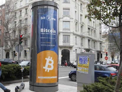 Un joven pasa junto a un panel de publicidad de bitcóin en Madrid. 