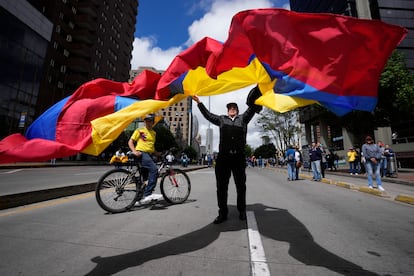 Manifestante ondea una bandera durante la 'Marcha de la Mayoría' convocada por la oposición, en Bogotá, el 20 de junio de 2023.