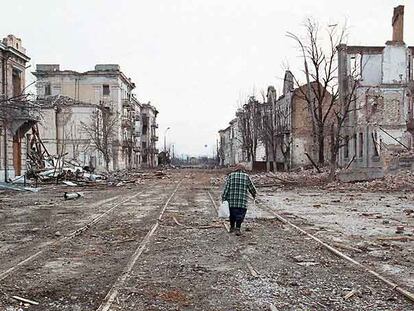 Una mujer camina por una calle de la devastada capital de Chechenia, Grozni, en una foto de marzo de 2000 tras la segunda guerra.
