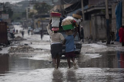 Dos vendedoras caminan por una calle inundada en el centro de Puerto Príncipe, Haití.