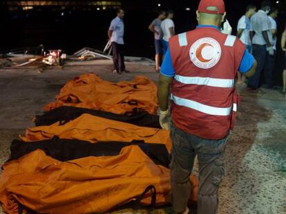 Un trabajador de la Media Luna Roja, junto a los cadáveres del naufragio que tuvo lugar en Zuwara.