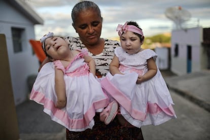 Heloisa (d) y Heloa (i) Barbosa, ambas nacidas con microcefalia, posan con su abuela para una foto el día de su cumpleaños, frente a su casa en Areia (Brasil). 