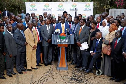 El líder de la oposición keniana, Raila Odinga (centro) anuncia que no se presentará a las elecciones del 26 de octubre, en Nairobi este martes.