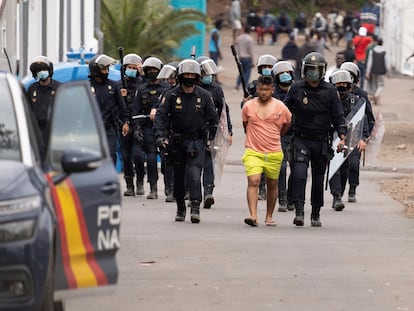 Policías antidisturbios trasladan a un detenido del campamento humanitario de Las Raíces tras los altercados ocurridos en el campamento de La Laguna (Tenerife).