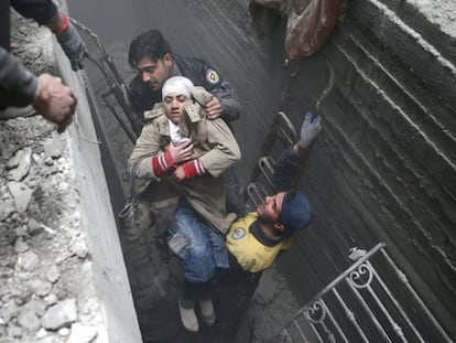 Miembros de la Defensa Civil Siria rescatan a una mujer tras un bombardeo en Duma.