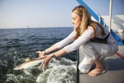 Alexandra Cousteau libera una cría de tiburón.