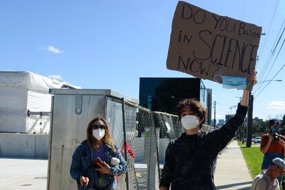 Un chico sostiene un cartel que dice "¿Crees en la ciencia ahora?'' frente al hospital militar donde Donald Trump estaba siendo tratado de covid, el pasado 3 de octubre.