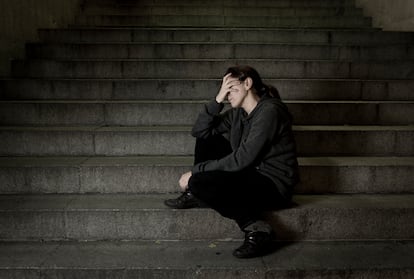 Una mujer sentada sola en unas escaleras.