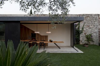 La fachada trasera de la casa es móvil. Sus grandes ventanales permiten convertir la cocina-comedor y el salón en porches abiertos al exterior durante el verano.