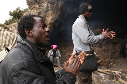 Desde la gruta se abren unas vistas escalofriantes de los bosques cercanos, por los que se reparte una cincuentena de africanos divididos según nacionalidades y religiones. No saben si algunos de sus camaradas desaparecidos están muertos, porque muchos huyeron de la zona después del enfrentamiento con la Guardia Civil. En la imagen, unos inmigrantes cantan en el interior de la cueva donde viven en Marruecos.