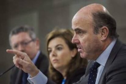 El ministro de Economía y Competitividad, Luis de Guindos, la vicepresidenta del Ejecutivo, Soraya Sáenz de Santamaría y el titular de Justicia, Alberto Ruiz Gallardón (d a i), durante la rueda de prensa posterior a la reunión del Consejo de Ministros celebrada esta mañana en La Moncloa.