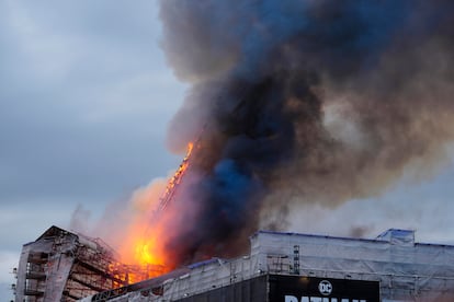 Momento en que las llamas han derribado el icónico chapitel del edificio de la Bolsa de Copenhague, este martes.