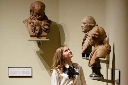 A museum assistant poses with "Bust of a Man" by Augustin Pajou (1761) (L), "Bust of a Man" by Pierre Merard (1786) (C) and "Michel-Jean Sedaine" by Augustin Pajou (1775) displayed within the Victoria and Albert museum's new "1600-1815" galleries in London on December 7, 2015. The V&A's seven new gallery areas hold nearly 1,100 objects and will open to the public on 9 December, 2015. 
AFP PHOTO / LEON NEAL