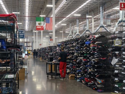 Un trabajador organiza camisetas en los estantes de la fábrica de TSC Miami en Ciudad Juárez, estado de Chihuahua (México), en 2021.