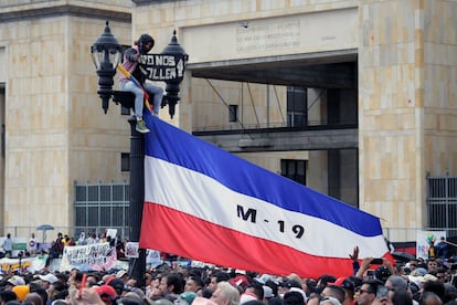 Un hombre cuelga una bandera del M-19 (Movimiento 19 de Abril), antiguo grupo guerrillero que se convirtió en el partido político Alianza Democrática en la década de los 90,  en la plaza de Bolívar, el 7 de agosto de 2022.