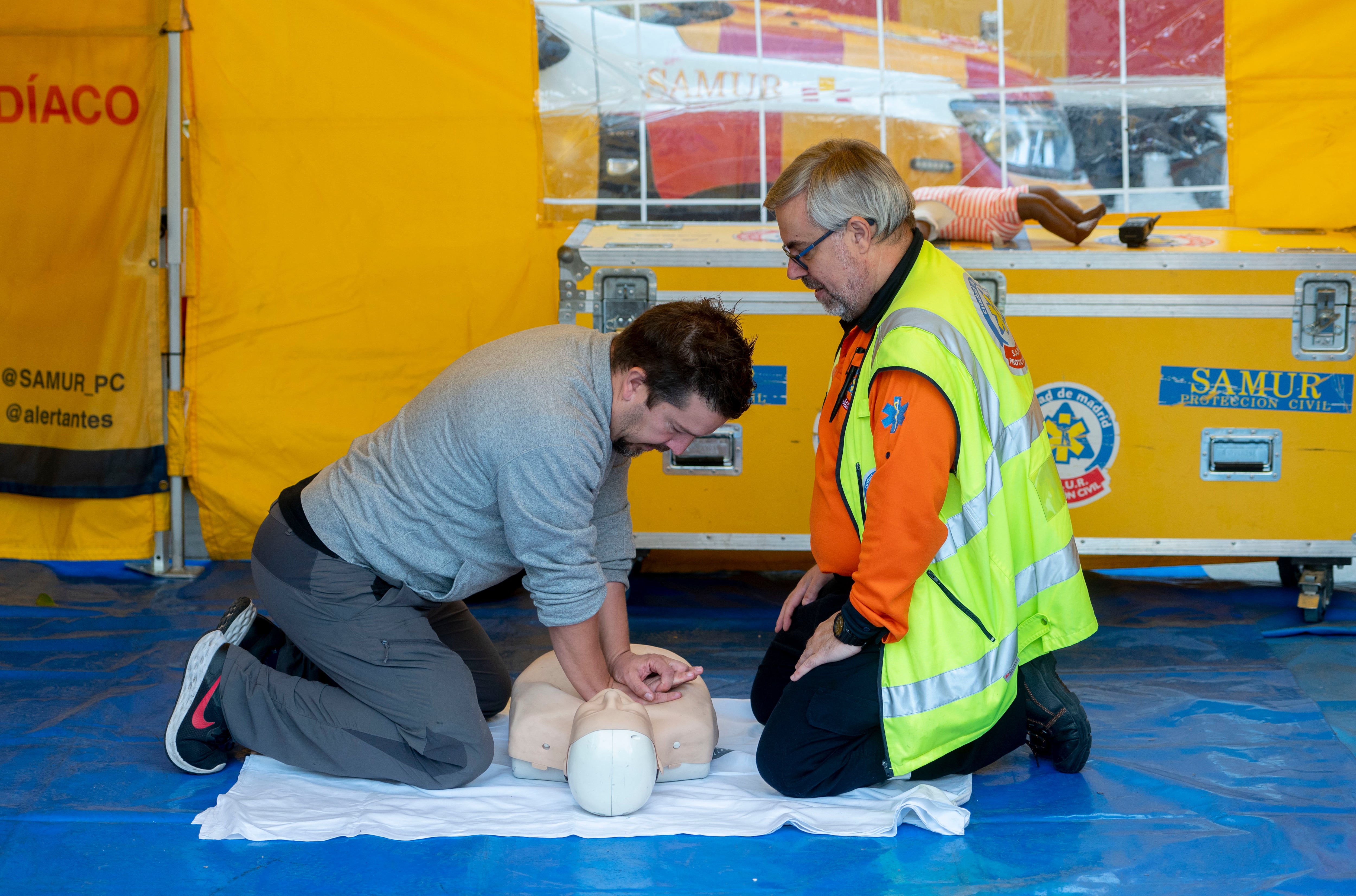 Dos personas realizan una técnica de reanimación cardiopulmonar durante la actividad instalada por SAMUR-PC en Madrid, el 16 de octubre de 2023.