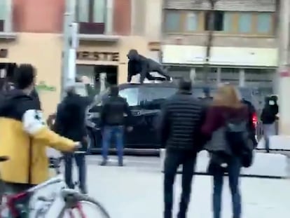 Una manifestante salta sobre una furgoneta de Vox, en Vic (Barcelona).