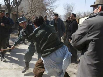 Un policía afgano golpea a un manifestante ayer frente a la Embajada danesa en Kabul.