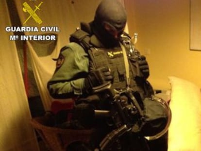 Un guardia civil custodia a uno de los detenidos de la operaci&oacute;n Periplo.