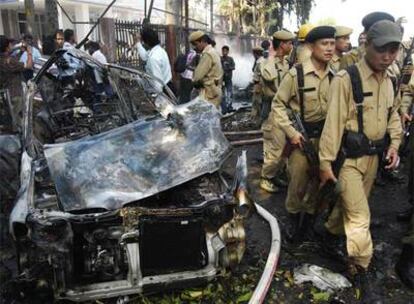 Policías indios caminan alrededor de un coche que ha explotado en Guwahati, noroeste de India.