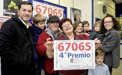 Un cuarto premio del Sorteo del Gordo de Navidad ha recaído en la localidad de Peligros (Granada), vendido en la administración de lotería 67.065 situada en la calle Felix Rodríguez de la Fuente del pueblo de Peligros. En la imagen, los dueños de la administración de lotería Manuela Jiménez (sostiene el numero en sus manos) y Santiago González junto a su familia una vez conocido el premio.