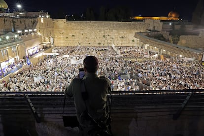 Un isrealí sigue desde un balcón la manifestación en la plaza del Muro de las Lamentaciones. 