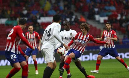 Antoine Griezmann controla el balón ante los jugadores del Valencia.