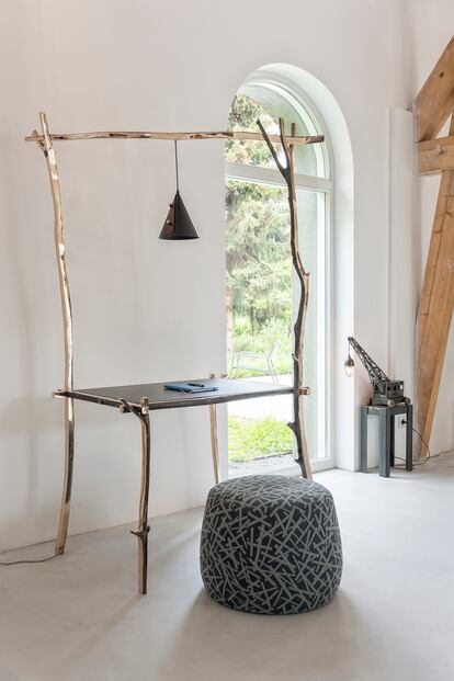 Kiki van Eijk moldeó con bronce ramas para idear su serie limitada Civilizad Primitives: esta mesa de trabajo y una cama de día que vende en la galería Nilufar de Milán. El puf es de Bernhard Design.