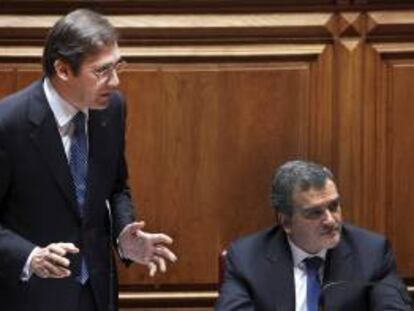 El primer ministro portugués, Pedro Passos Coelho (izda), interviene en un debate en el Parlamento junto al ministro portugués de Asuntos Parlamentarios, Miguel Relvas (dcha), en Lisboa (Portugal) hoy, viernes.