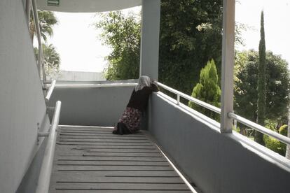 Una mujer de la tercera edad ora dentro de una de las casas de la colonia de la Hermosa Provincia.