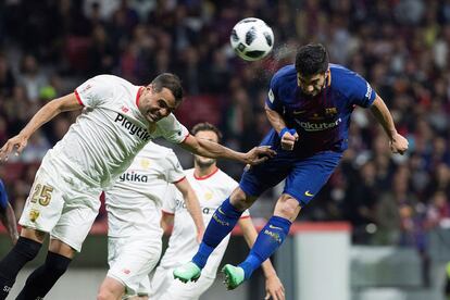 El delantero uruguayo del FC Barcelona, Luis Suárez (d), y el defensa argentino del Sevilla, Gabriel Mercado, disputan un balón durante la final.
