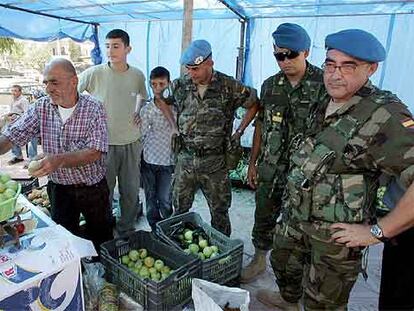 Varios soldados españoles compran manzanas a un frutero de Taibé.