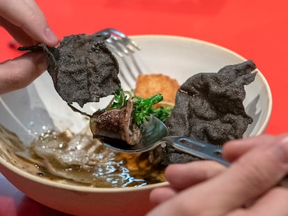 Un cliente de StreetXO come un plato de 'txipiron wok, arroz y calamansi' en el día de la reapertura del restaurante de Dabiz Muñoz en Madrid, el 19 de enero de 2022.
