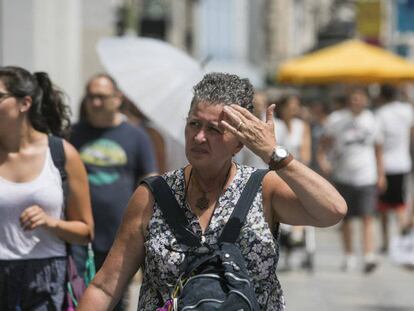 Una mujer se protege del sol con la mano en Madrid durante la ola de calor.