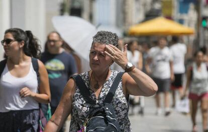 Una mujer se protege del sol con la mano en Madrid durante la ola de calor.