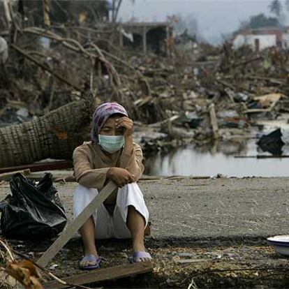 Julia, de 22 años, residente de Banda Aceh (Indonesia), se sienta desolada ante los restos de la casa de su abuela.
