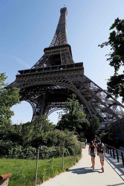 Los turistas se dirigen a la Torre Eiffel para subir, el primer día de la reapertura.