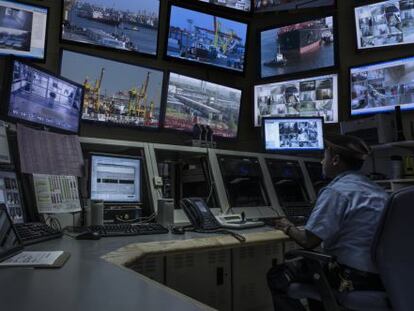 Un guardia de seguridad observa las pantallas de una sala de control.