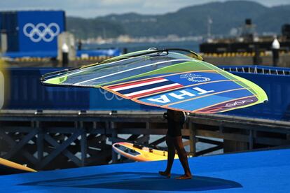 Un deportista de Tailandia lleva una vela de windsurf en el puerto de yates de Enoshima en Fujisawa.