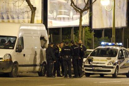 Agentes del Cuerpo Nacional de Policía, junto a la furgoneta sospechosa, en la que son visibles las consecuencias de la explosión.