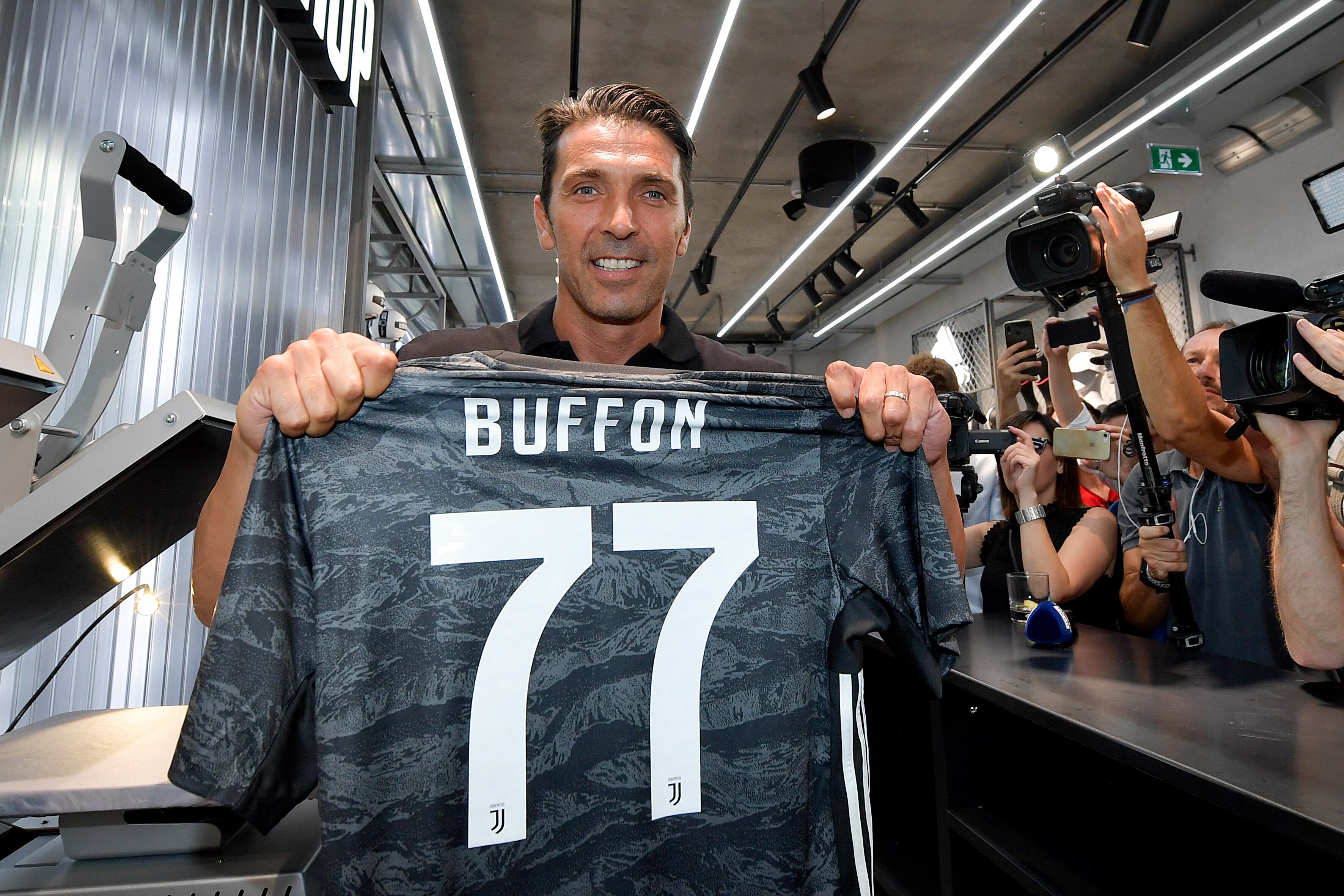 Gianluigi Buffon posa con su camiseta durante la apertura de la nueva tienda de la Juventus en Milán, 2019.