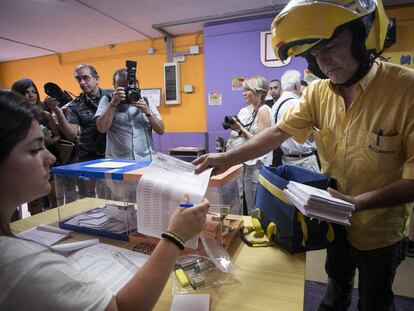 Un cartero trae a una mesa electoral el voto por correo en Hospitalet de Llobregat, Barcelona.