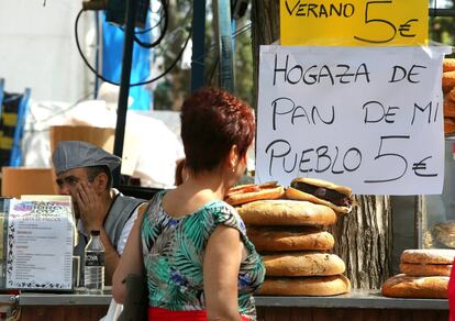 Una mujer mira una parada de comida en la feria de San Isidro.