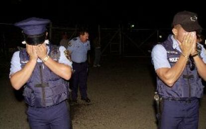 Policías puertorriqueños se protegen del impacto de una granada de gas lanzada por los <i>marines</i> en Campo García.