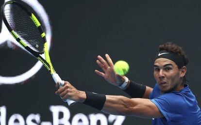 El tenista español Rafa Nadal devuelve la bola al estadounidense John Isner