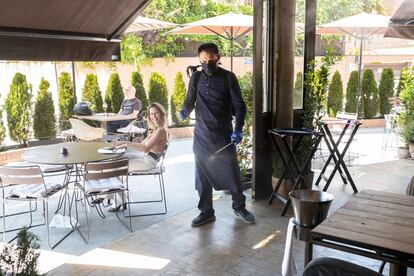 Marco, empleado del establecimiento Barbillon Oyster, desinfectando la terraza, esta mañana en Aravaca.