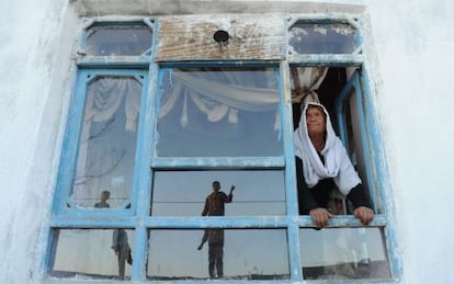 La viuda afgana Bibikoh se asoma a la ventana de su casa en Zanabad.