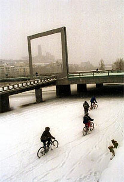 Un grupo de ciclistas se atreve con la nieve en la ciudad de Lleida.